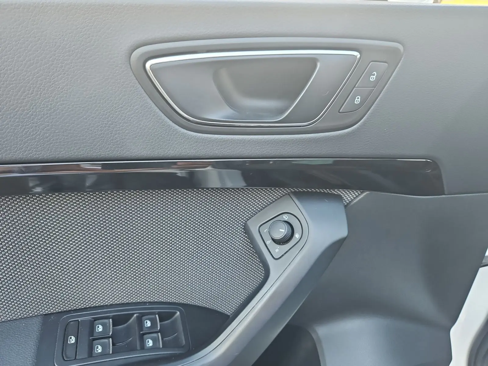 Détail de la porte avant gauche du SEAT Ateca blanc, avec commandes des vitres et réglage des rétroviseurs.