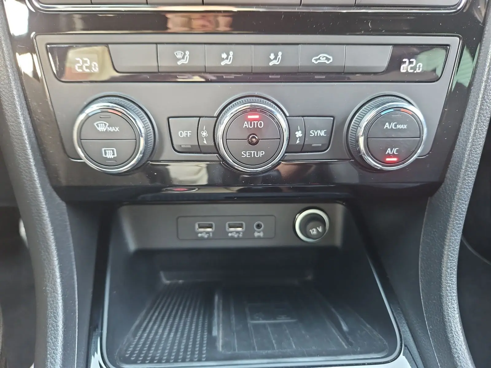 Vue rapprochée du tableau de bord de la SEAT Ateca blanc, montrant la climatisation automatique et ports USB.