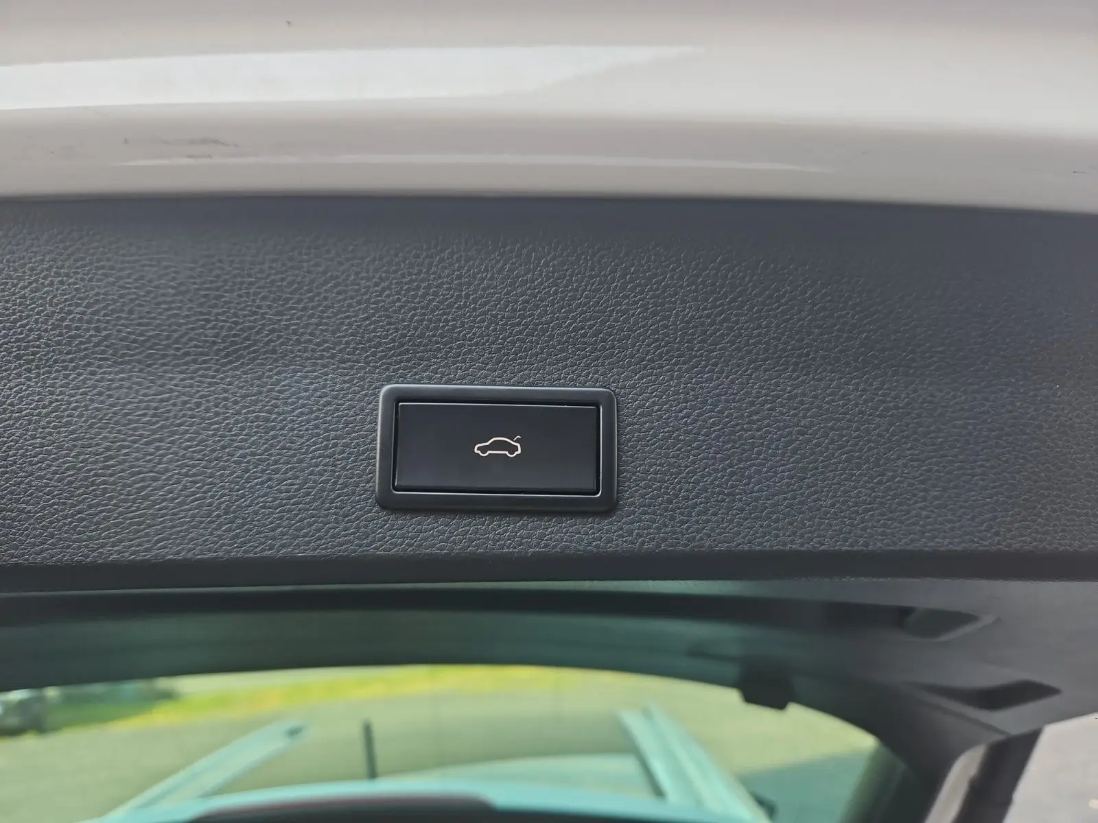 Bouton d'ouverture électrique du hayon sur la partie intérieure du coffre d'un SEAT Ateca blanc.