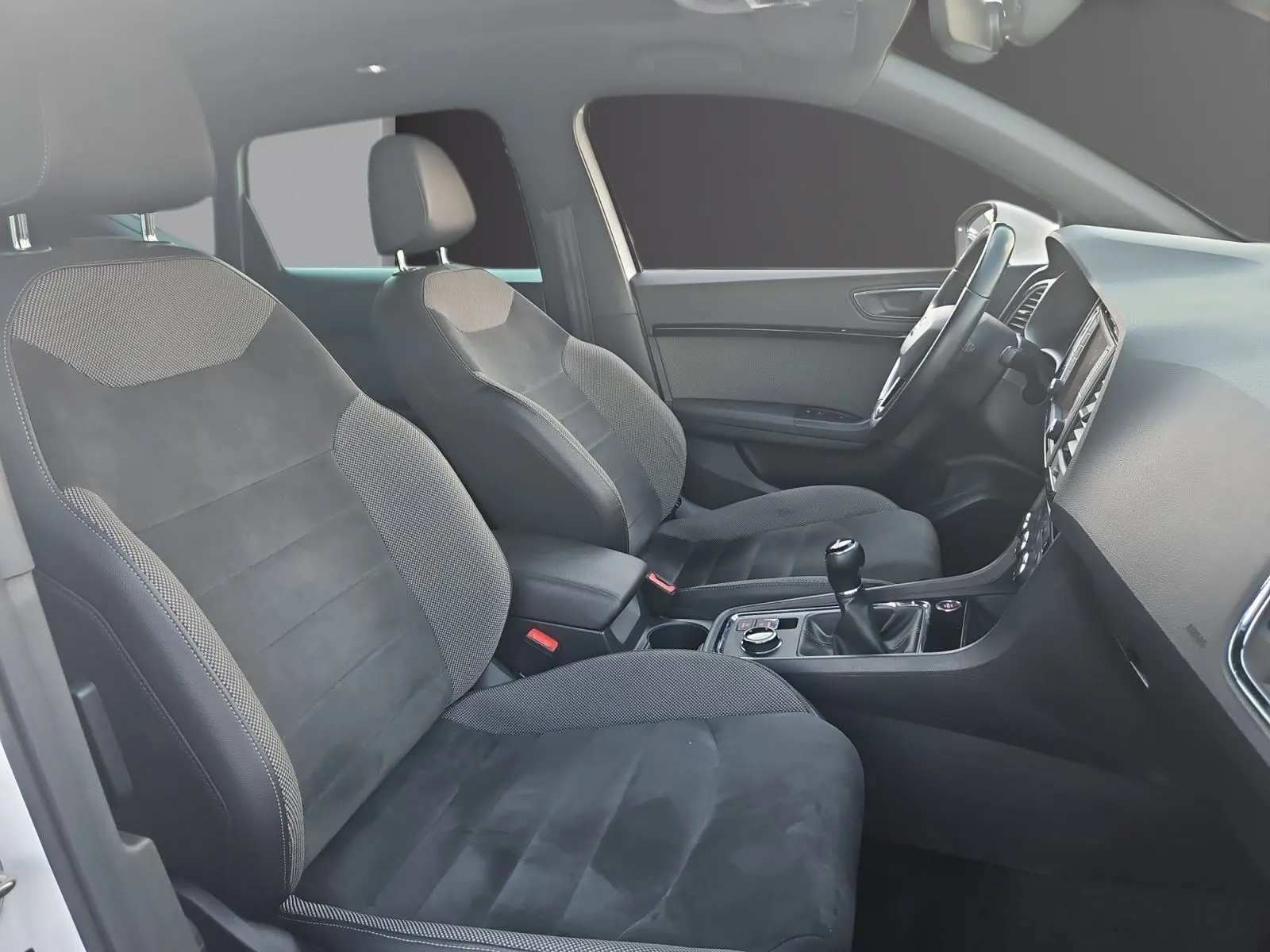 Vue intérieure côté conducteur du SEAT Ateca 2018, sièges cuir et alcantara noirs avec volant cuir et boîte manuelle.