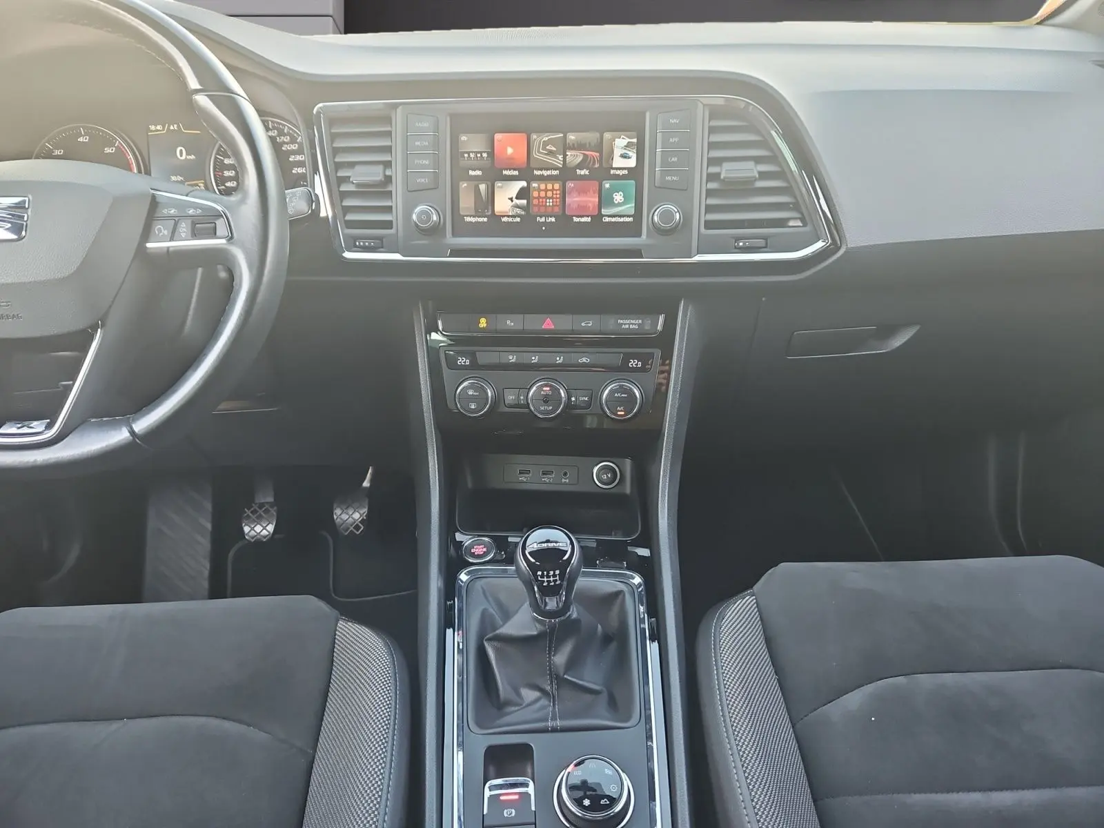 Vue intérieure frontale du tableau de bord et console centrale du SEAT Ateca 2.0 TDI, avec volant cuir et boîte manuelle.