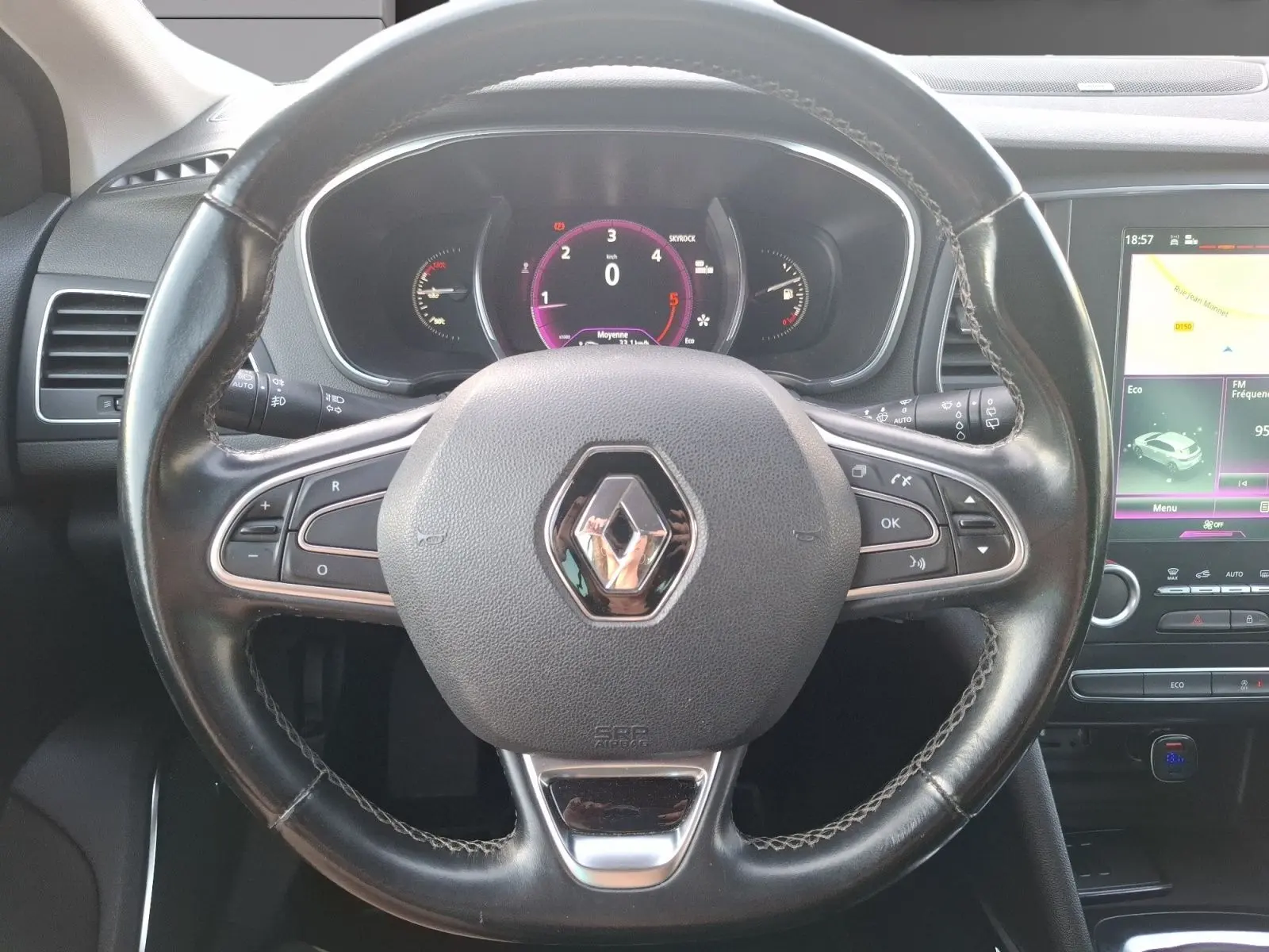 Vue rapprochée du volant noir de la Renault Mégane 1.6 DCI 130 Energy Intens avec tableau de bord numérique et écran tactile.