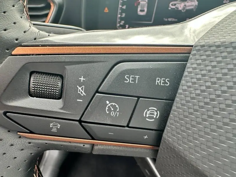 Gros plan sur les commandes du volant multifonction côté gauche du CUPRA Formentor noir Minuit 2024 avec finition cuivre.