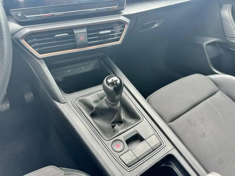 Intérieur de la CUPRA Formentor 2024 montrant la console centrale avec levier de vitesse manuel et sièges en tissu noir.