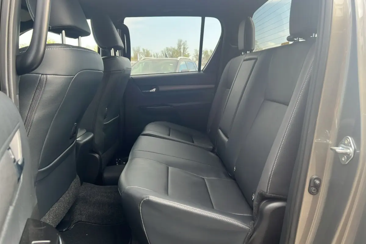 Vue intérieure côté droit montrant la banquette arrière en cuir noir du Toyota Hilux 4x4 Invincible 2025 bronze impérial.