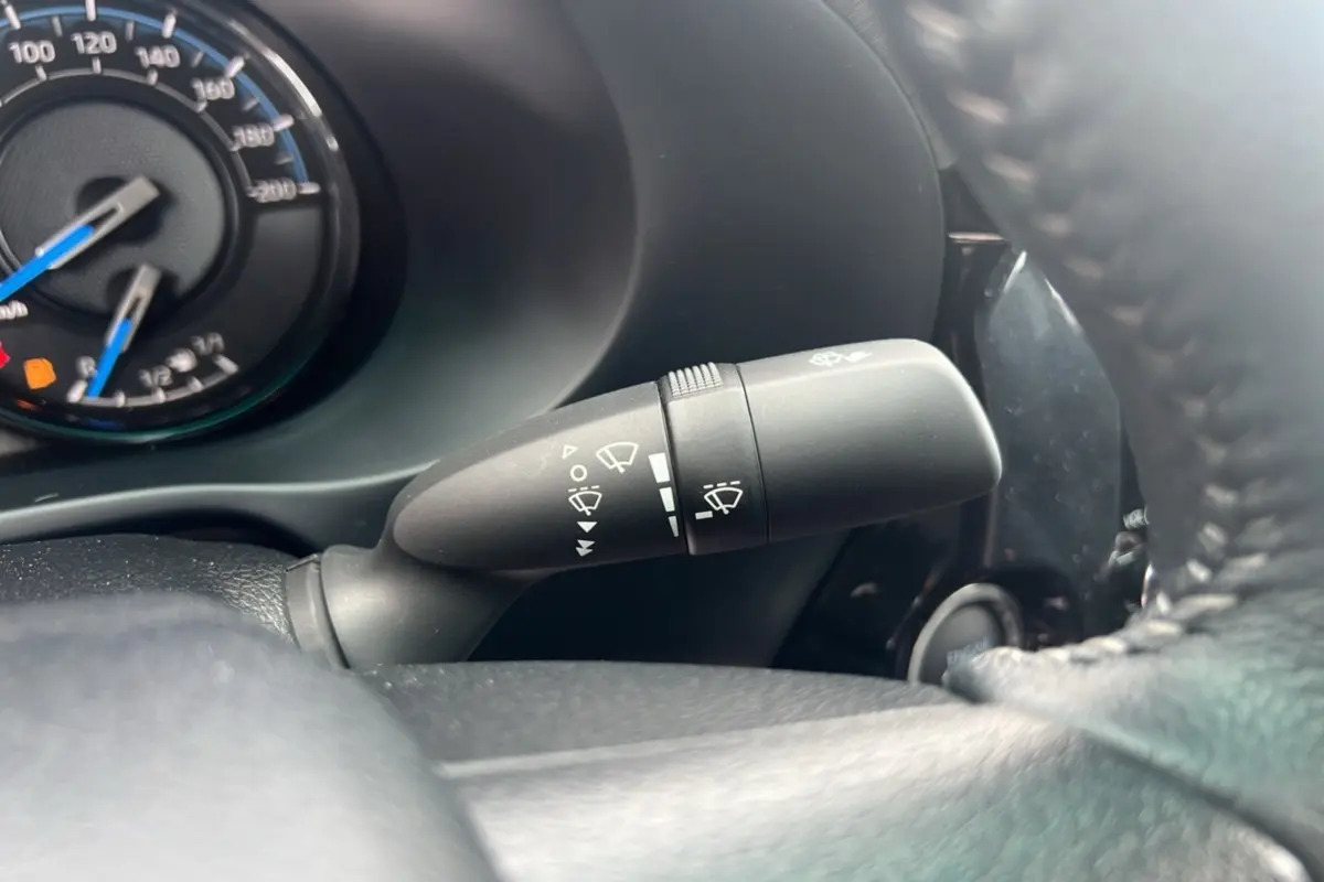 Gros plan sur la commande d'essuie-glace à gauche du volant du Toyota Hilux 2025, tableau de bord partiellement visible.