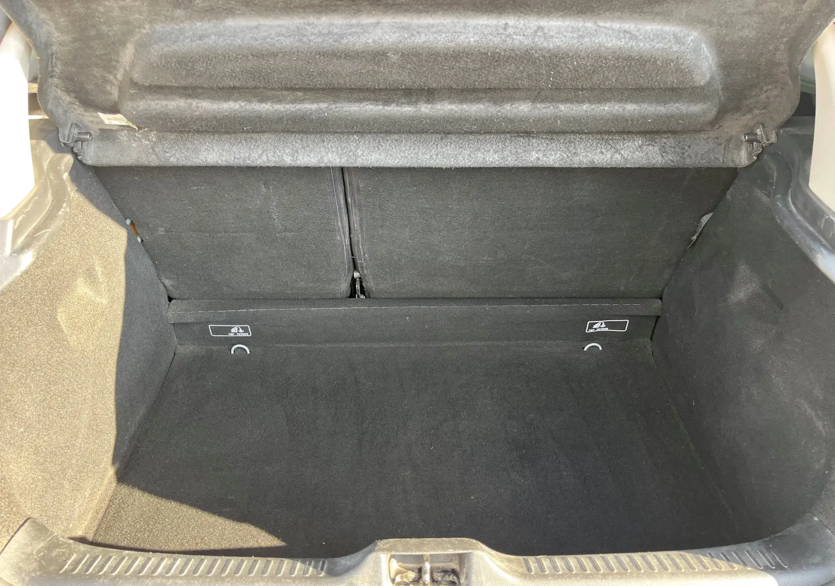 Coffre ouvert de la Renault Clio IV 1.5 DCI 90 de 2019, vue intérieure montrant un espace de chargement propre et noir.