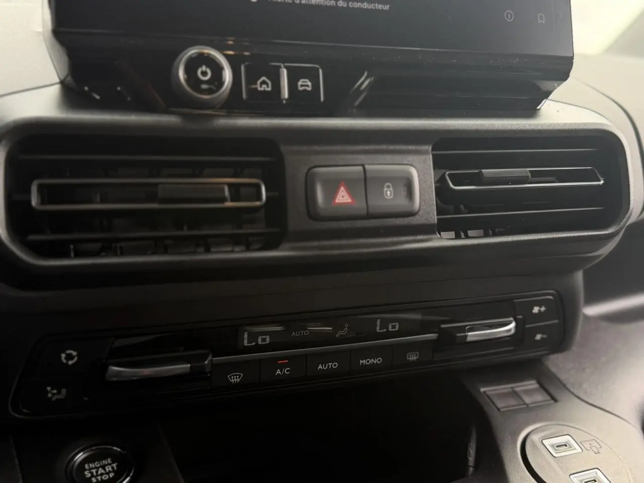 Gros plan sur la console centrale du Peugeot Rifter 2026, montrant les aérateurs et commandes de climatisation.