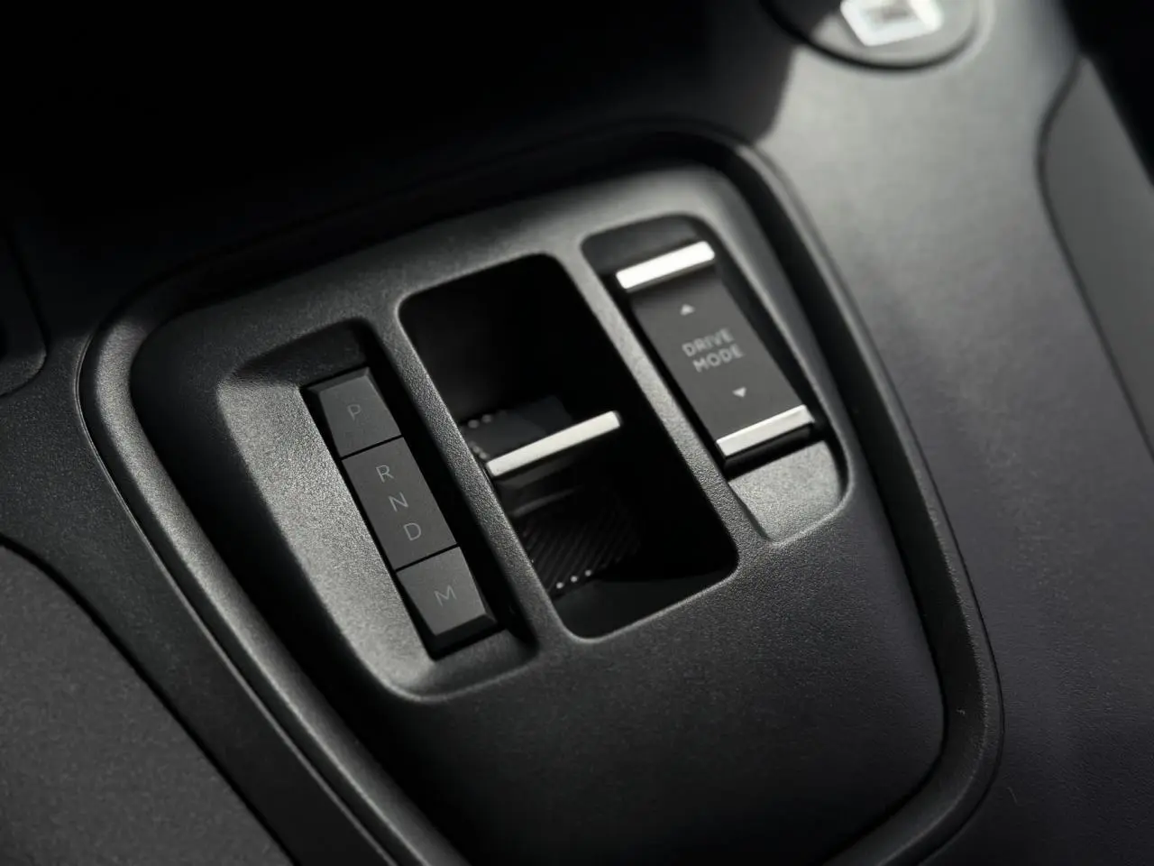 Gros plan sur la console centrale noire du Peugeot Rifter 2026, avec commandes de boîte auto et mode de conduite.