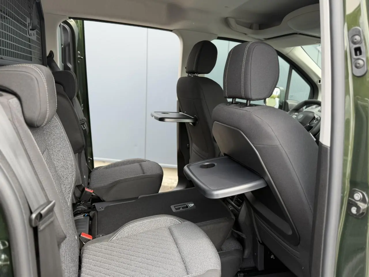 Intérieur du Peugeot Rifter vert Sirkka, vue côté droit sur les trois sièges individuels avec tablettes rabattables.