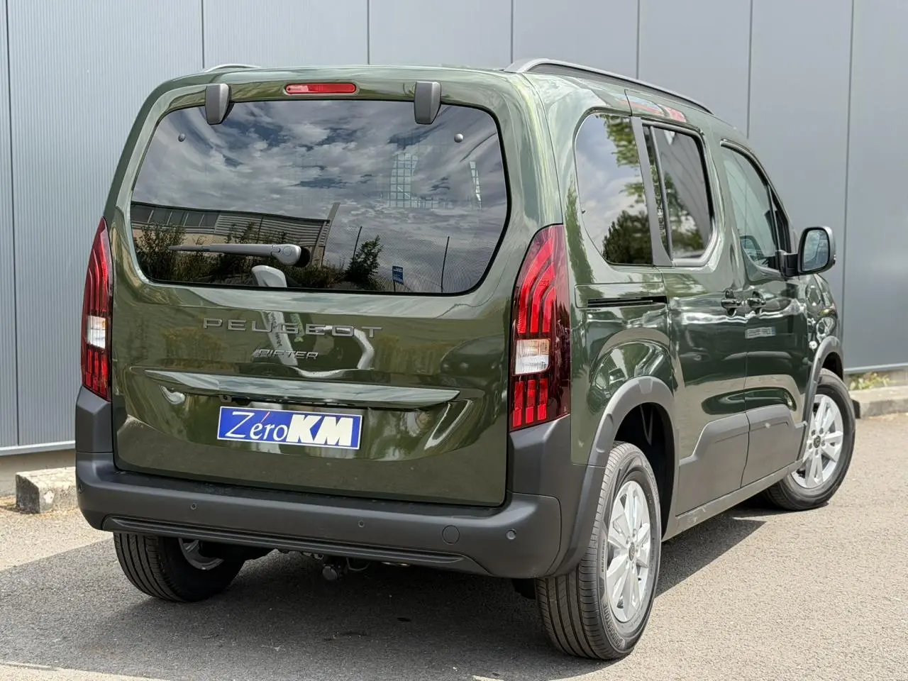 Vue 3/4 arrière droite du Peugeot Rifter 2026 vert Sirkka avec portes latérales coulissantes et vitres arrière surteintées.