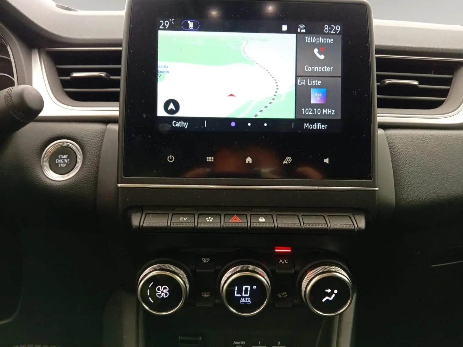 Vue rapprochée de la console centrale du Renault Captur E-Tech 2023, écran tactile et commandes climatisation visibles.