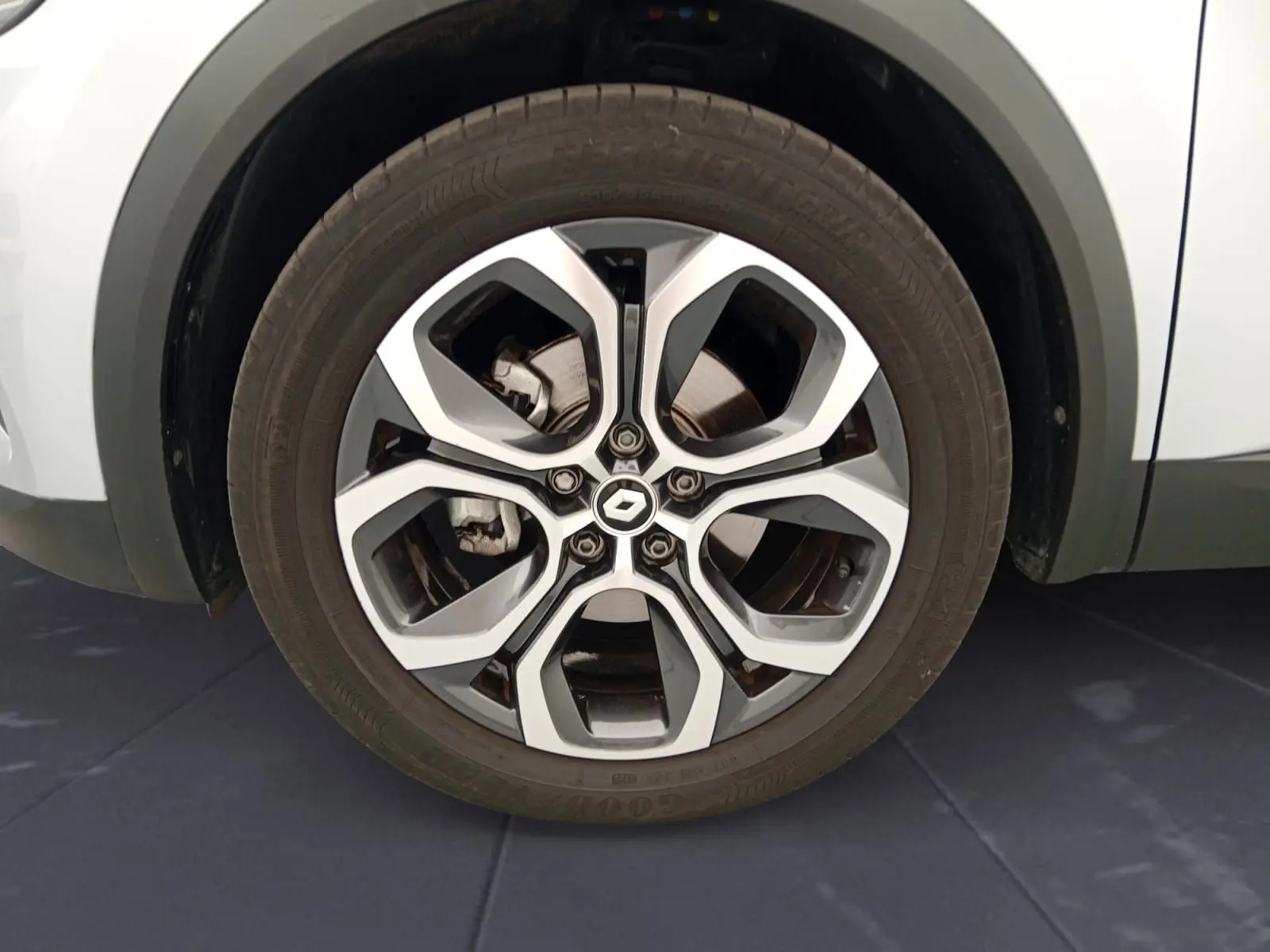 Gros plan sur la roue avant droite du Renault Captur gris alu/noir, mettant en valeur la jante alliage 18 pouces au design moderne.