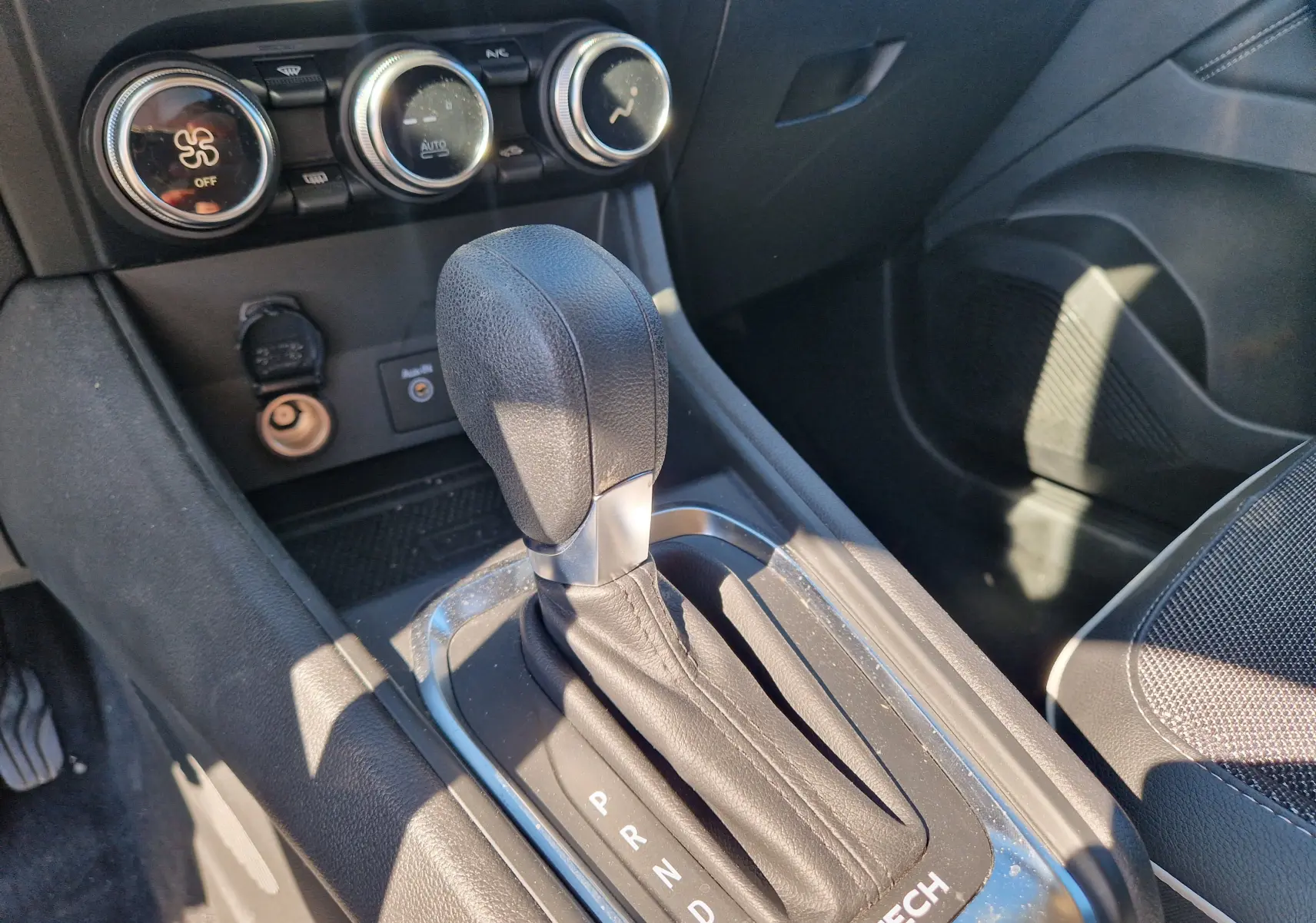 Le levier de vitesse automatique noir du Renault Captur E-Tech 145, avec commandes de climatisation en arrière-plan.