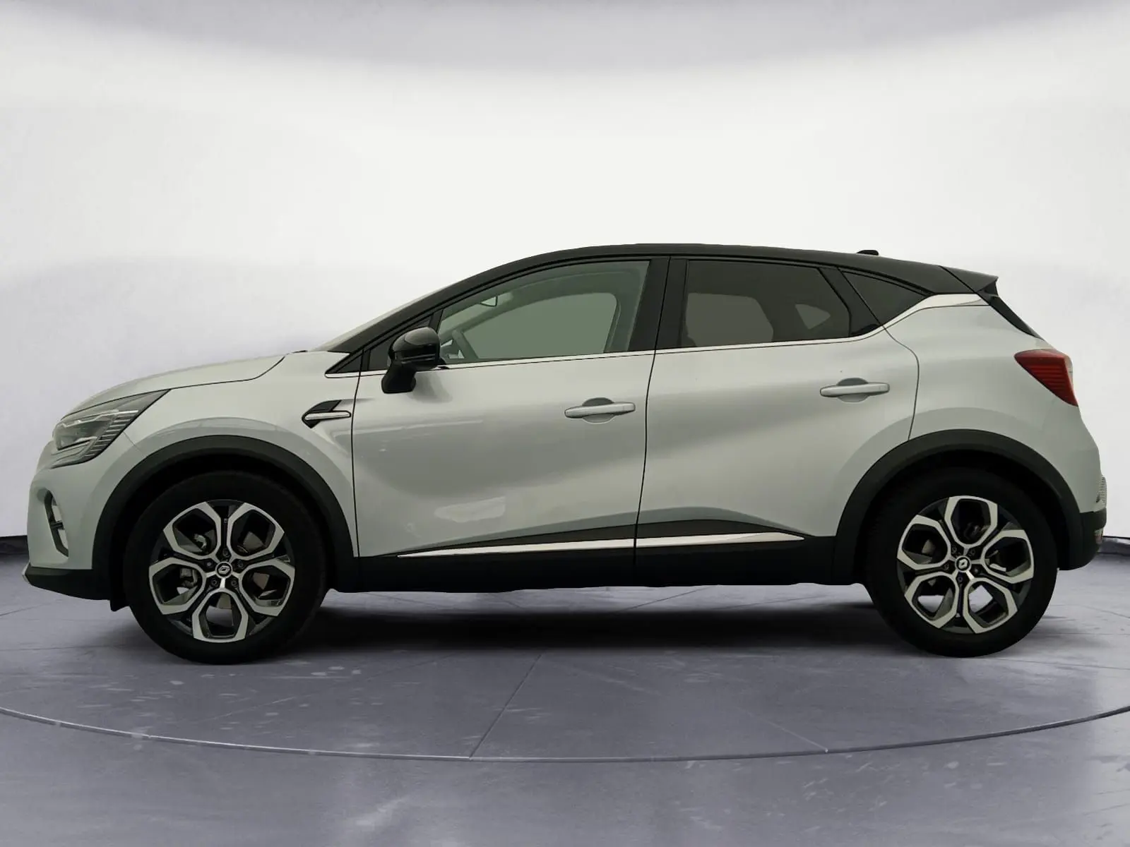 Profil droit du Renault Captur E-Tech Full Hybrid 145 Techno 2023 en gris alu avec toit noir et jantes 18 pouces.