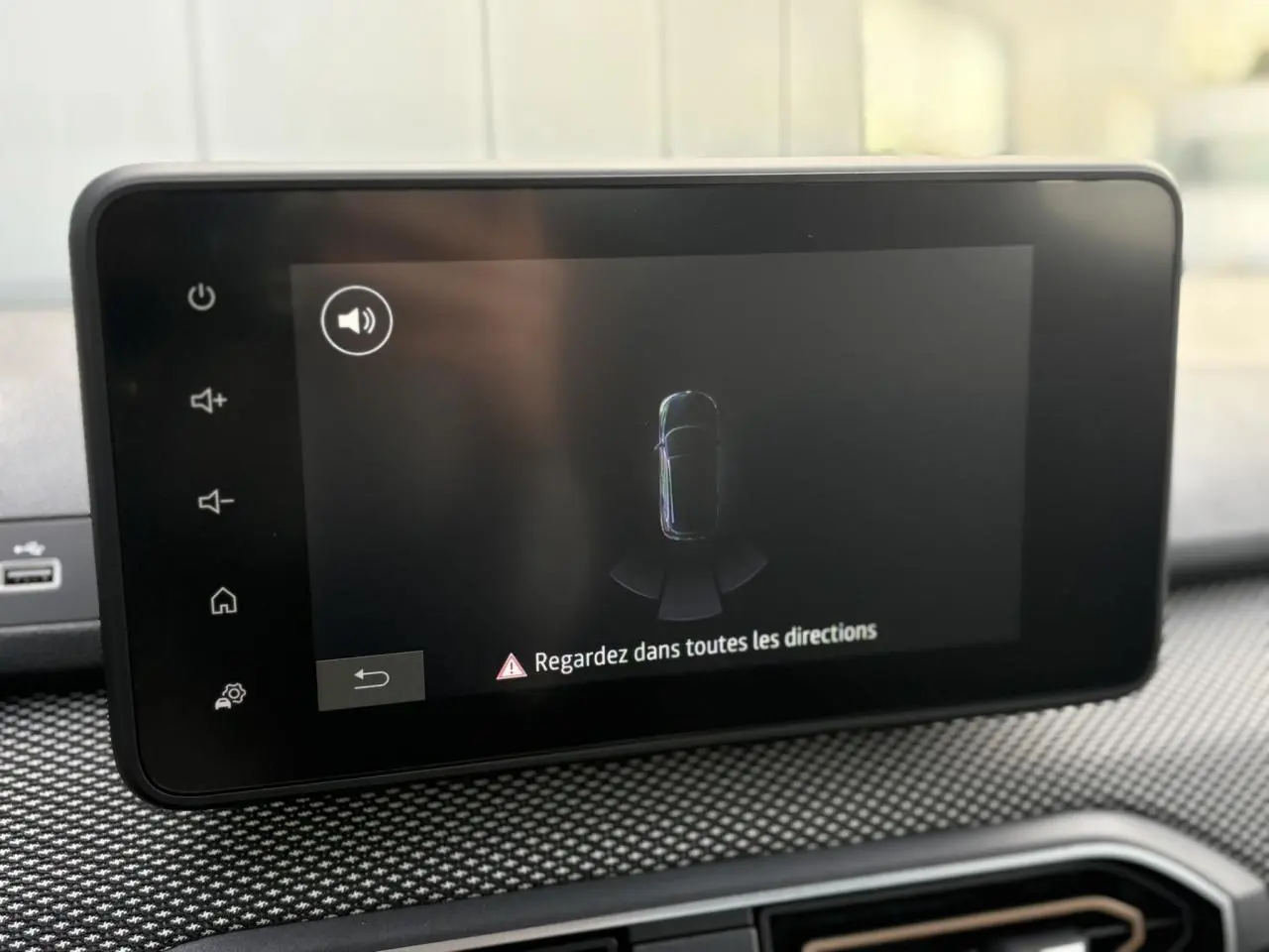 Écran tactile central du tableau de bord de la Dacia Sandero Stepway 2025 affichant l'aide au stationnement arrière.