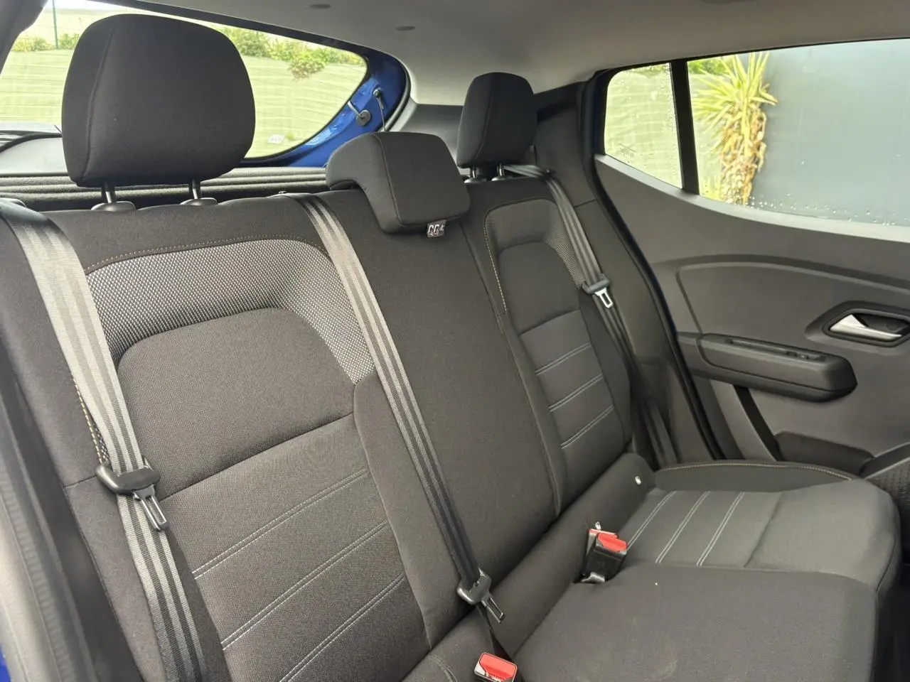 Vue intérieure côté droit des sièges arrière noirs avec appuie-têtes du Dacia Sandero Stepway Bleu Iron 2025.