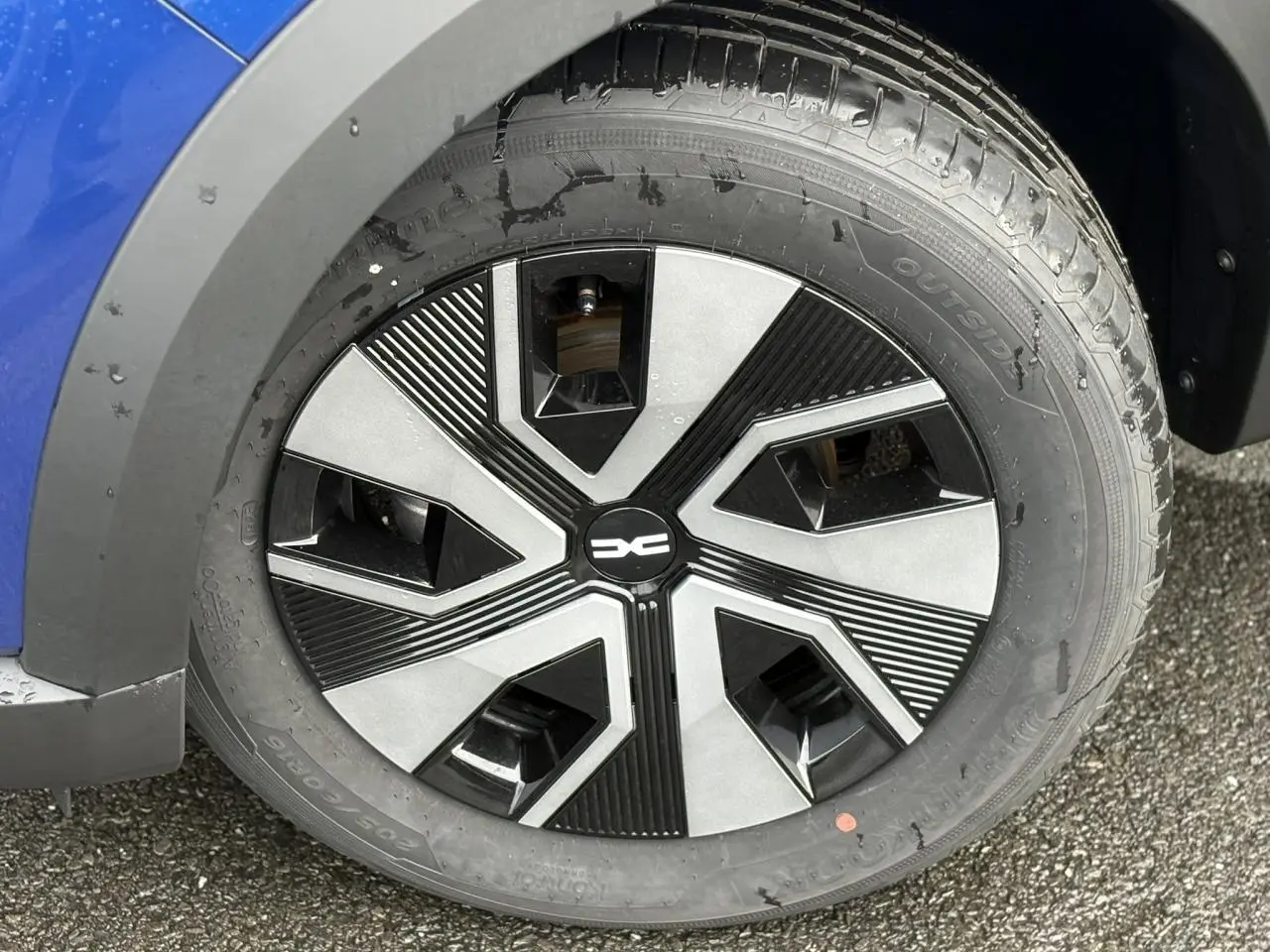 Gros plan sur la roue avant gauche d'une Dacia Sandero Stepway 2025 Bleu Iron avec jante 16 pouces Atara Dark.