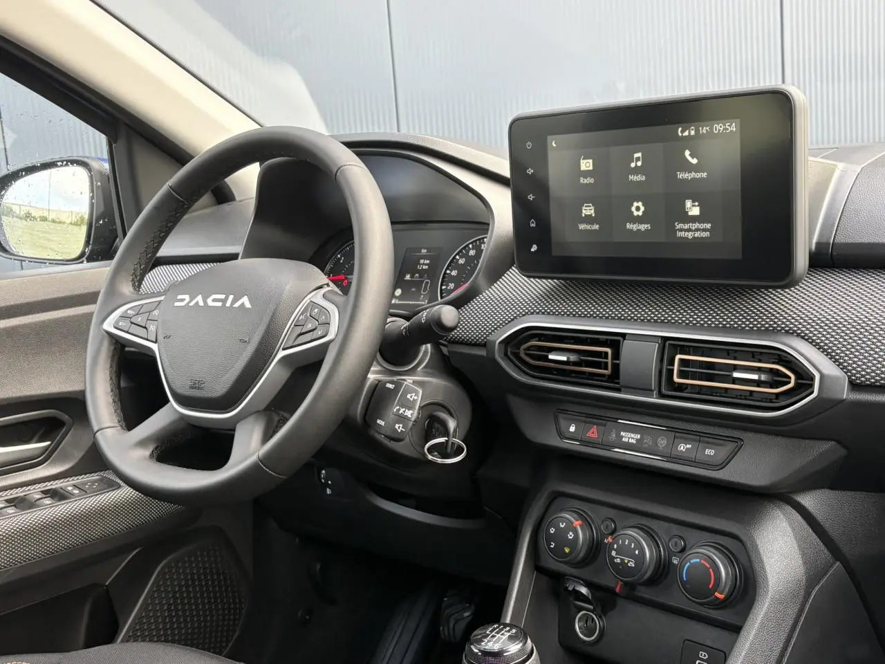 Vue intérieure côté conducteur du tableau de bord du Dacia Sandero Stepway 2025 avec écran tactile et volant noir.