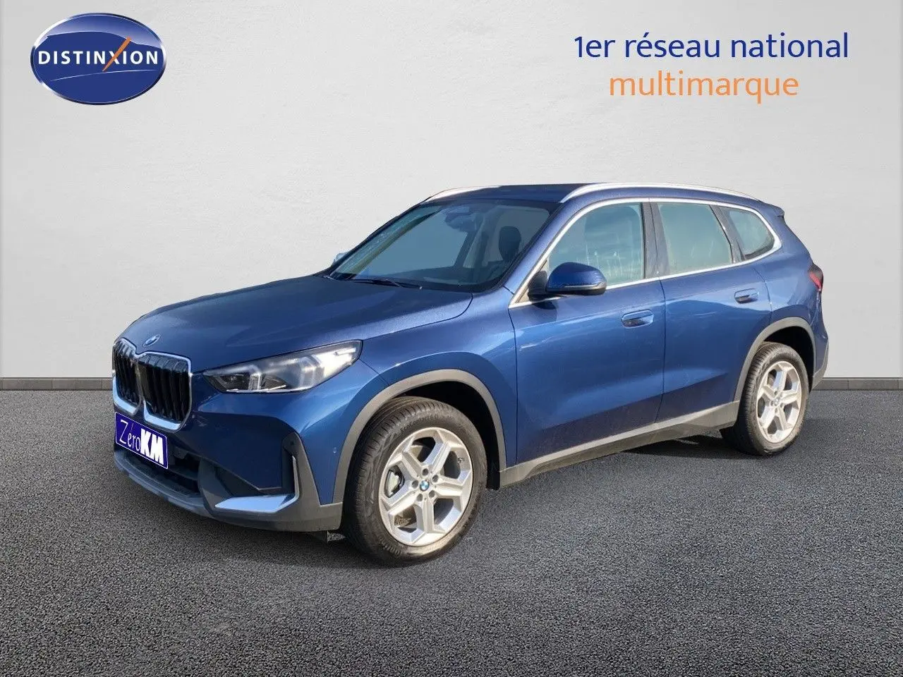 BMW X1 18I 136CH bleu Phytonic metal en 3/4 avant droit, mettant en valeur sa calandre et ses jantes argentées.
