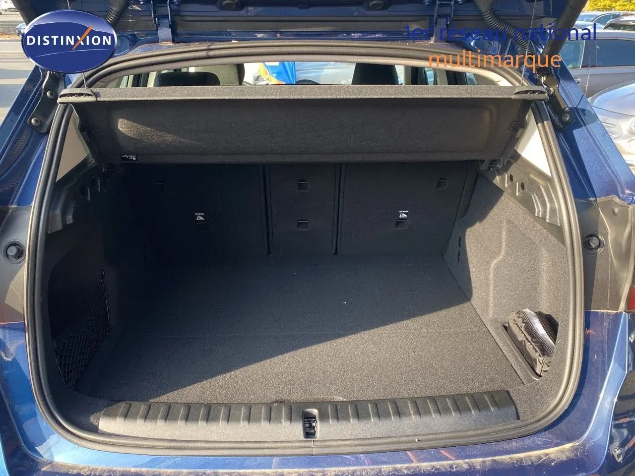 Coffre ouvert vu de l'arrière d'un BMW X1 18I Business Design bleu Phytonic Metal, espace de chargement vide et propre.