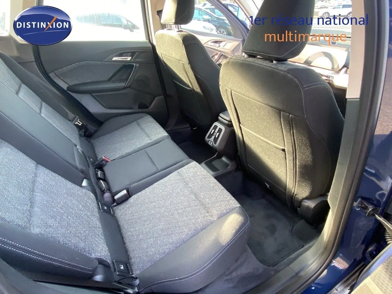 Vue intérieure arrière droite du BMW X1 18I 136CH bleu Phytonic avec sièges tissu gris et noir.