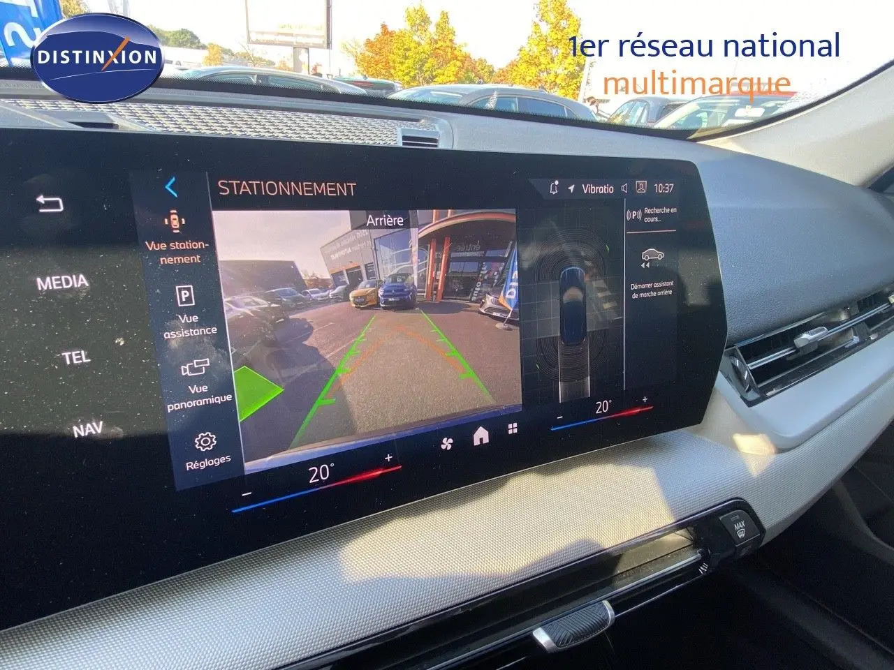 Vue intérieure du tableau de bord du BMW X1 18I 2024 avec écran affichant la caméra de recul et l'assistance au stationnement.