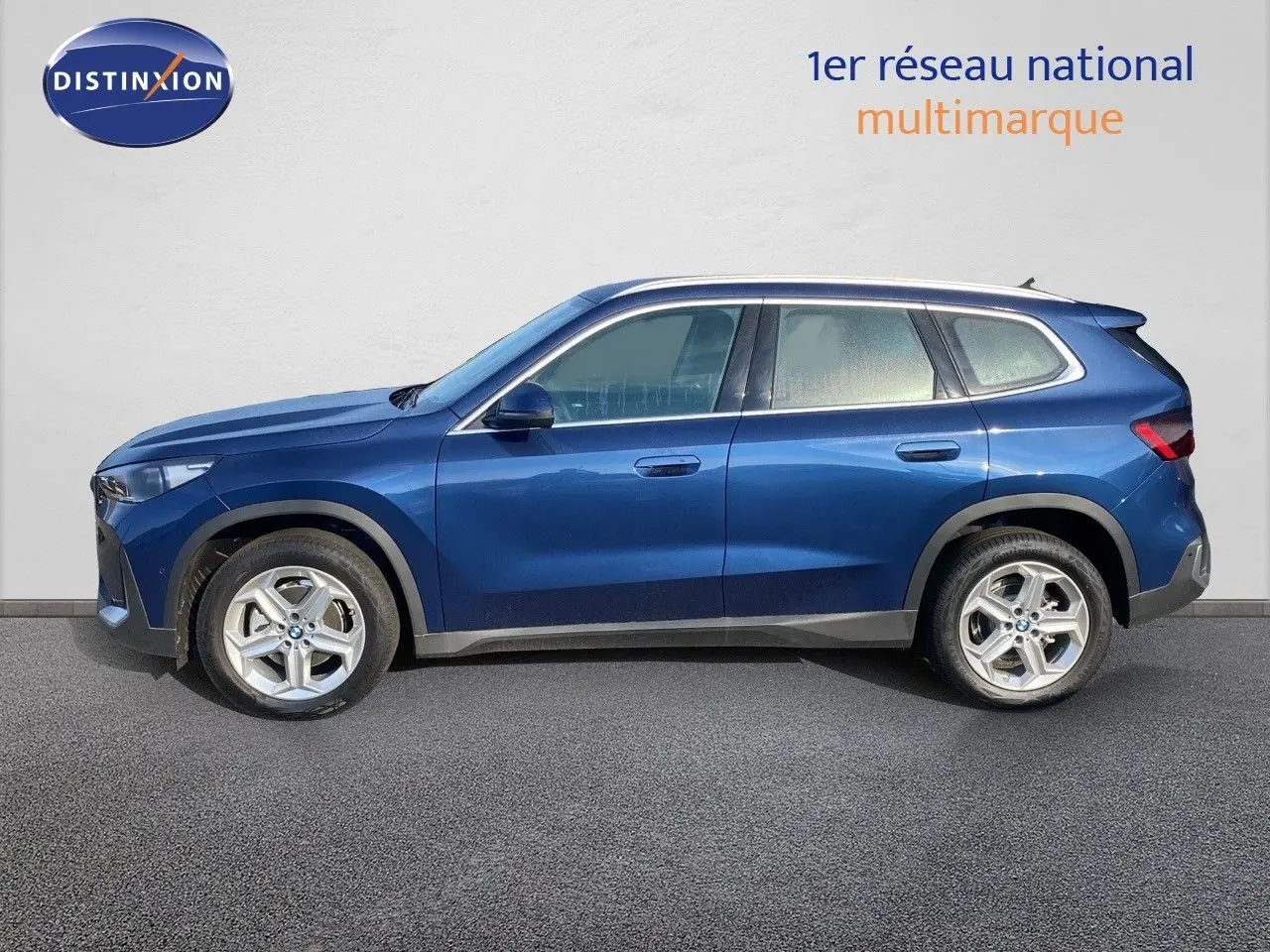 BMW X1 18I 136CH bleu Phytonic Metal vu de profil côté gauche, avec jantes alliage et lignes épurées.