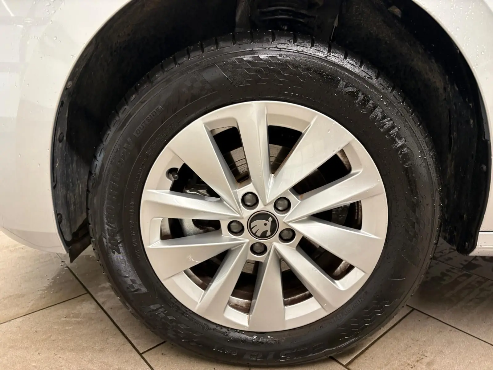 Gros plan sur la roue avant gauche avec jante alliage argentée du Skoda Kamiq gris argent 2025.