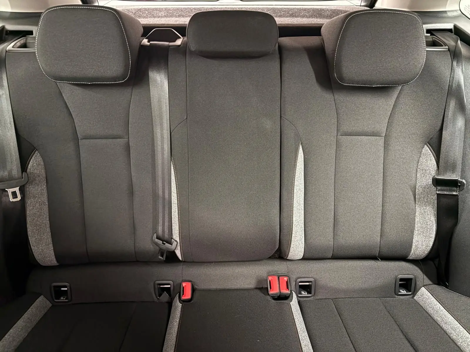 Vue intérieure de la banquette arrière du Skoda Kamiq 2025, sièges tissu gris avec ceintures et appuie-têtes.