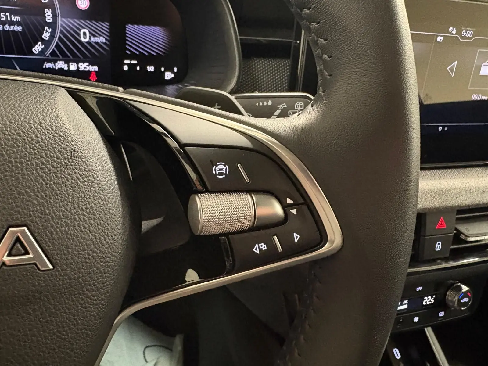 Gros plan sur le volant côté gauche du Skoda Kamiq gris argent 2025 avec commandes intégrées et tableau de bord numérique.