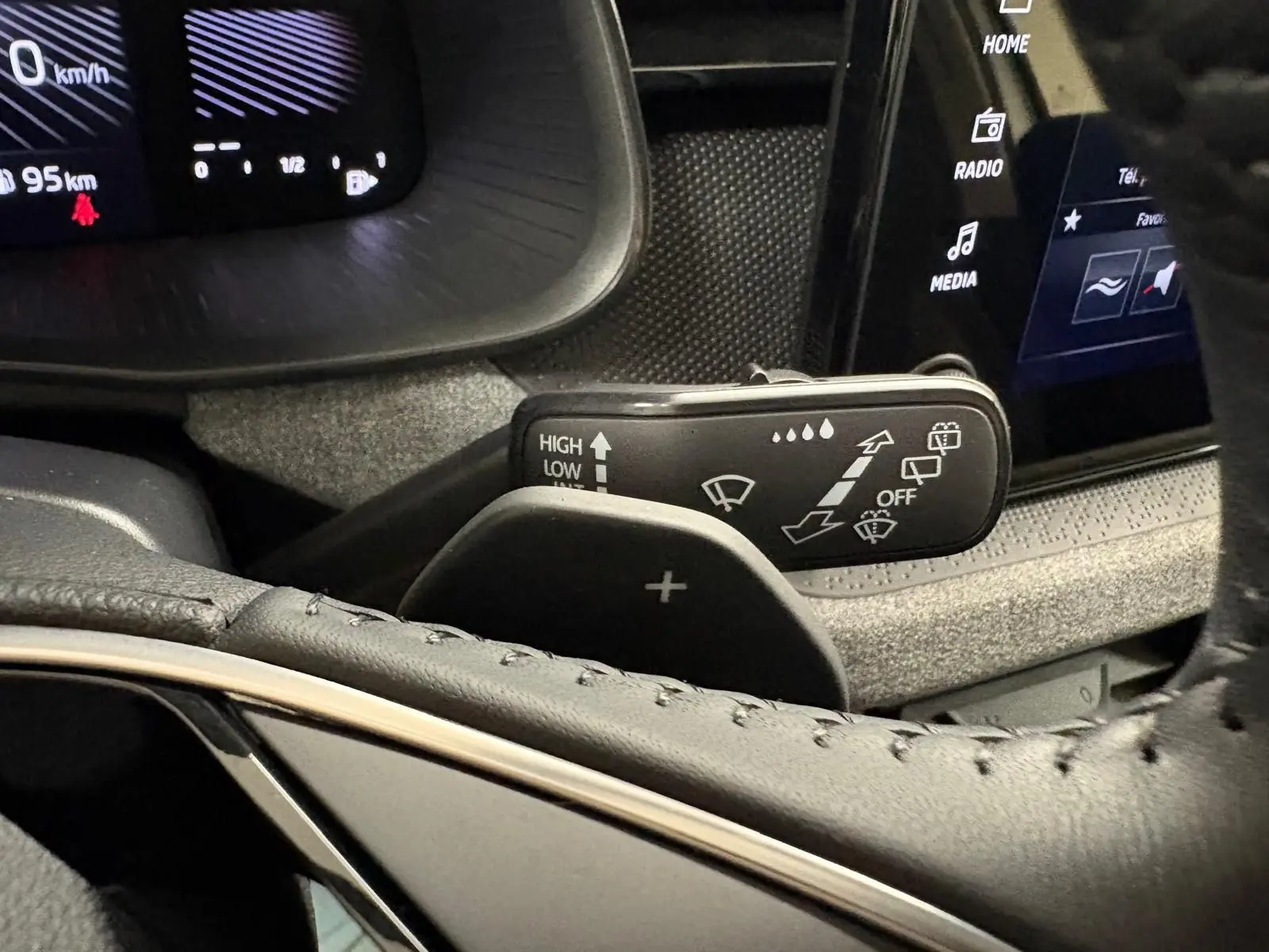 Gros plan sur la commande d’essuie-glace et palette de changement de vitesse dans l’habitacle du Skoda Kamiq gris argent.