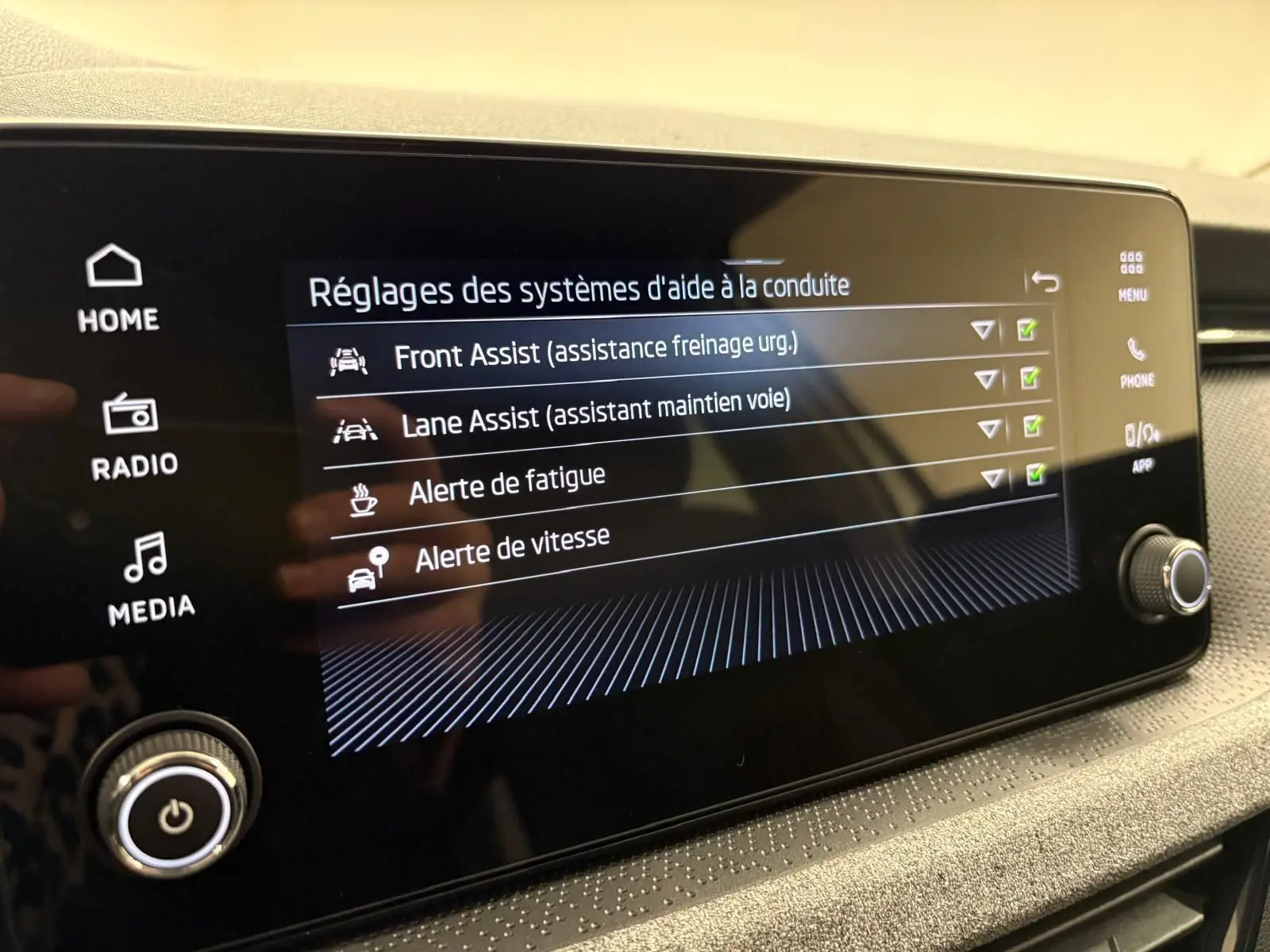 Écran tactile intérieur du Skoda Kamiq 2025 montrant les réglages d’aide à la conduite avec interface moderne.