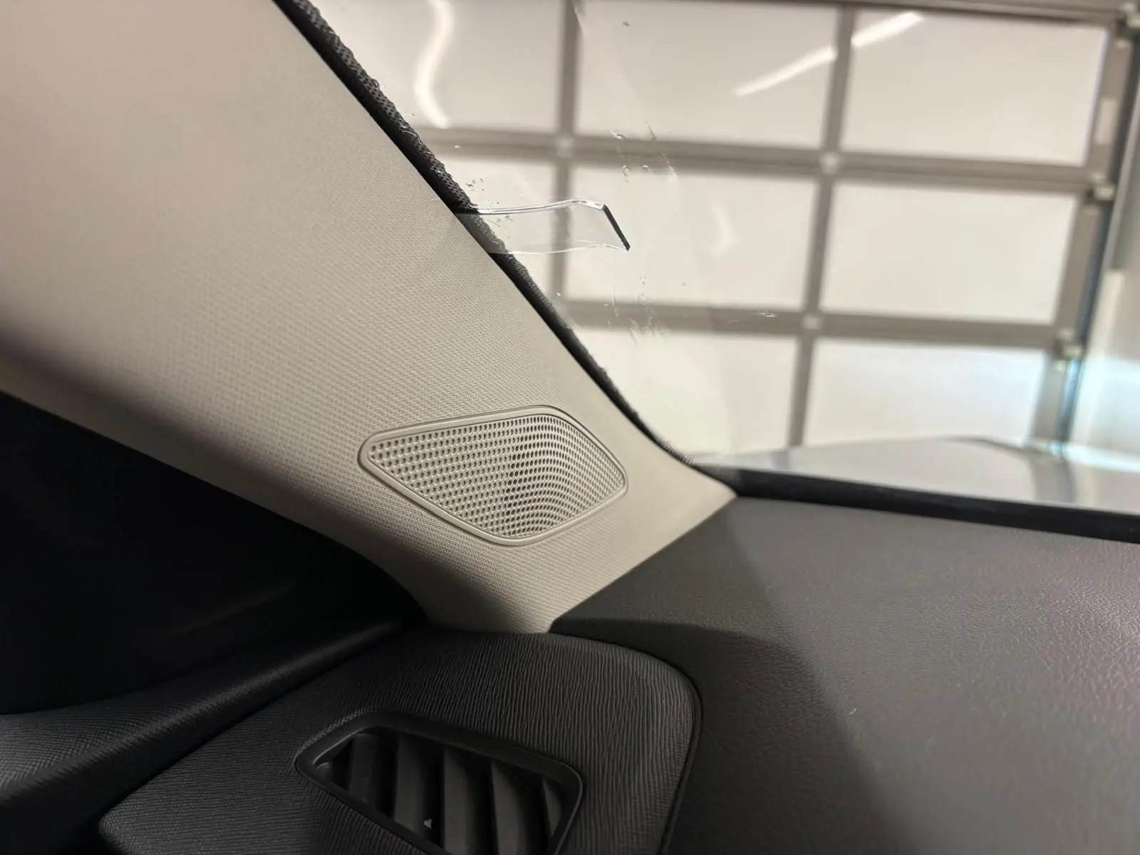 Détail intérieur côté gauche du tableau de bord gris avec haut-parleur intégré sur Skoda Kamiq 2025.