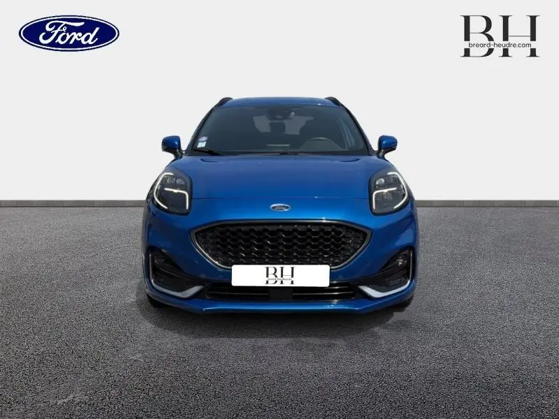 Vue frontale d'un Ford Puma 1.0 EcoBoost bleu métallisé avec calandre noire et phares LED distinctifs.