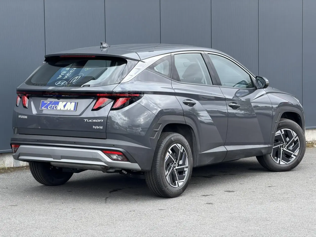 Hyundai Tucson 1.6 T-GDI Hybrid gris Ecotronic, vue 3/4 arrière droit, jantes alliage 17 pouces et feux LED distinctifs.
