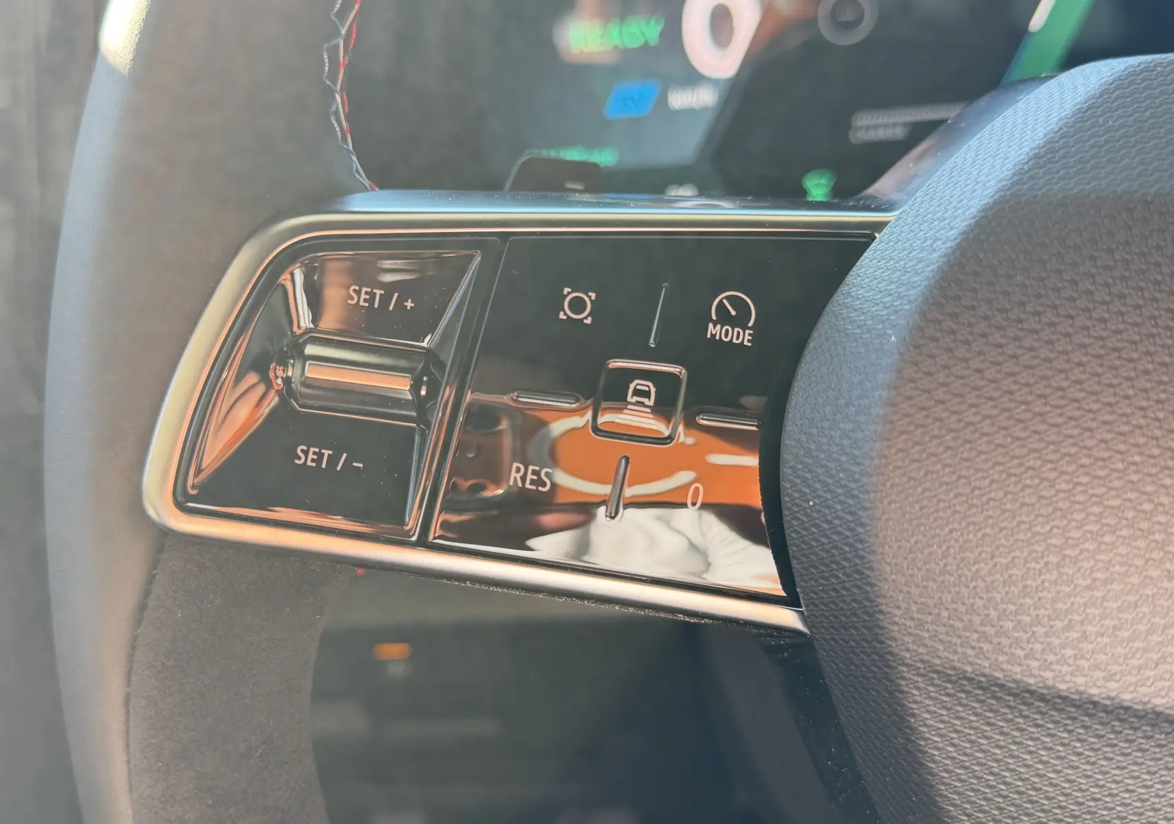 Gros plan sur les commandes de régulateur de vitesse au volant du Renault Austral E-Tech blanc nacré.