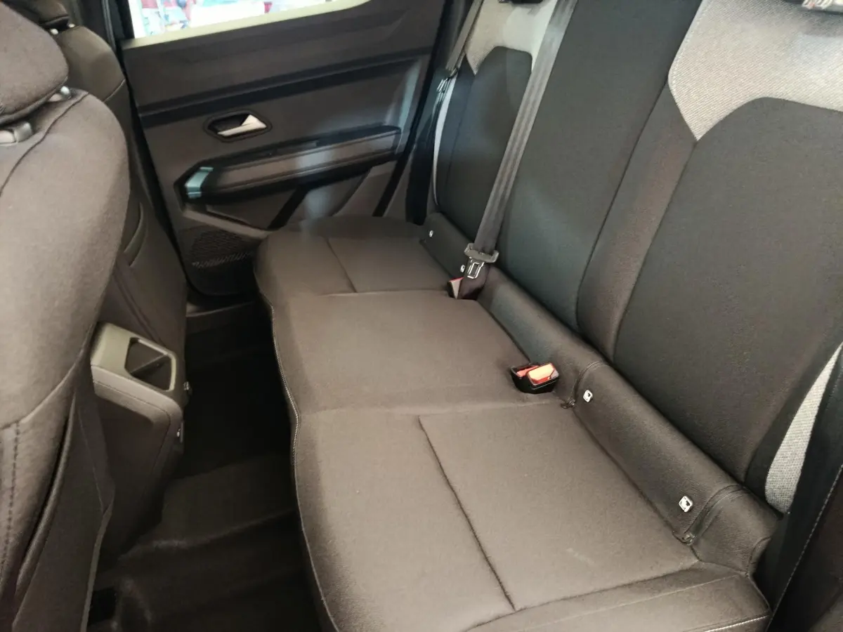 Vue intérieure côté droit sur la banquette arrière noire du Dacia Duster Journey Hybrid 155, avec ceinture et fixation Isofix visibles.