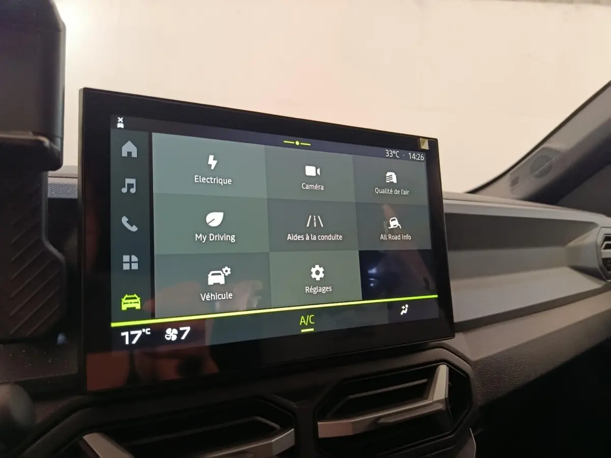 Écran tactile central du tableau de bord du Dacia Duster Journey Hybrid 155, affichant les options de conduite.