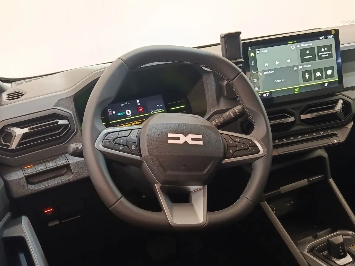 Vue intérieure du tableau de bord du Dacia Duster Journey Hybrid 155 2026 avec volant multifonctions et écran tactile central.