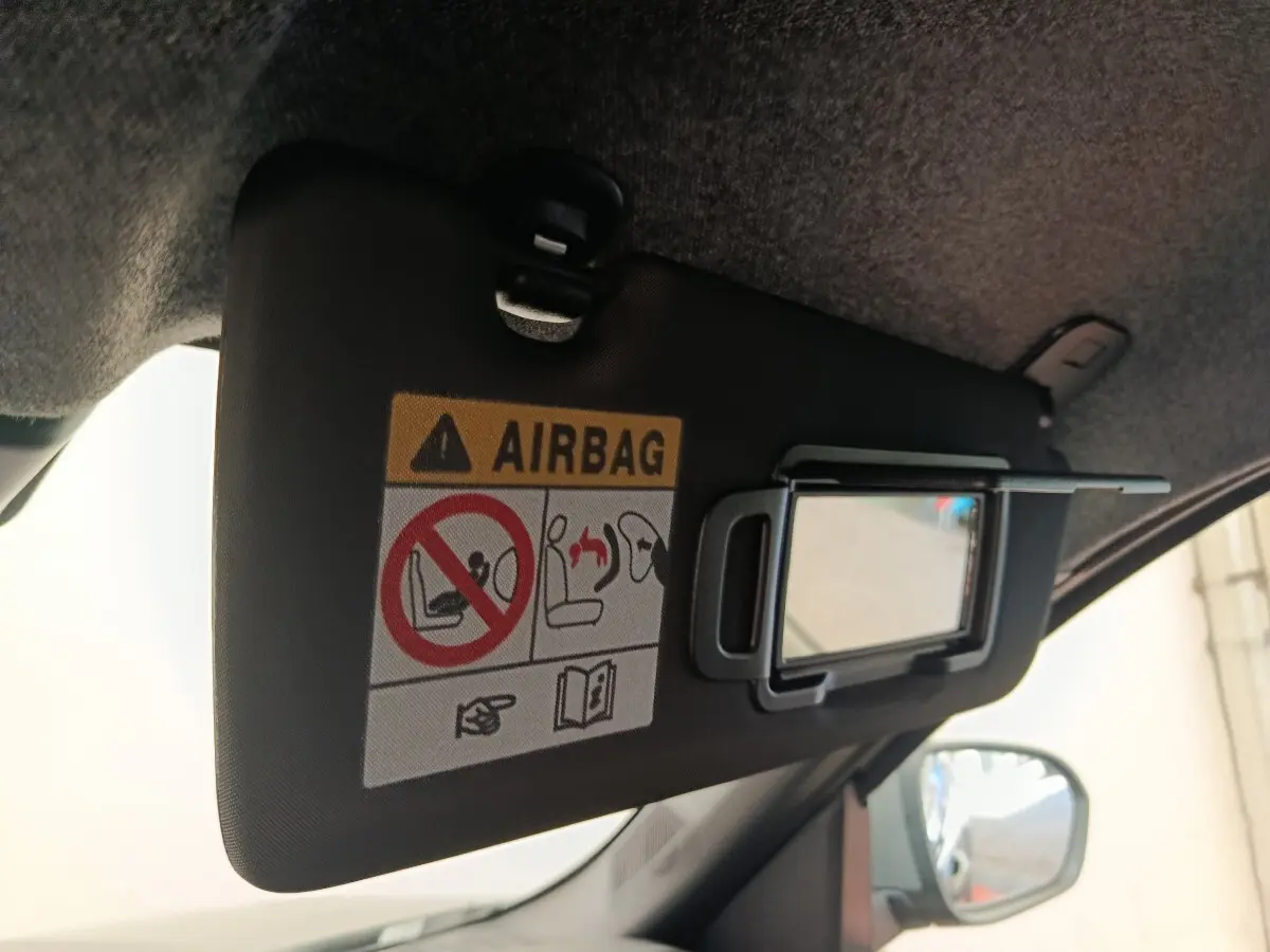 Détail intérieur du pare-soleil côté conducteur du Dacia Duster noir 2026, avec miroir et avertissement airbag visible.