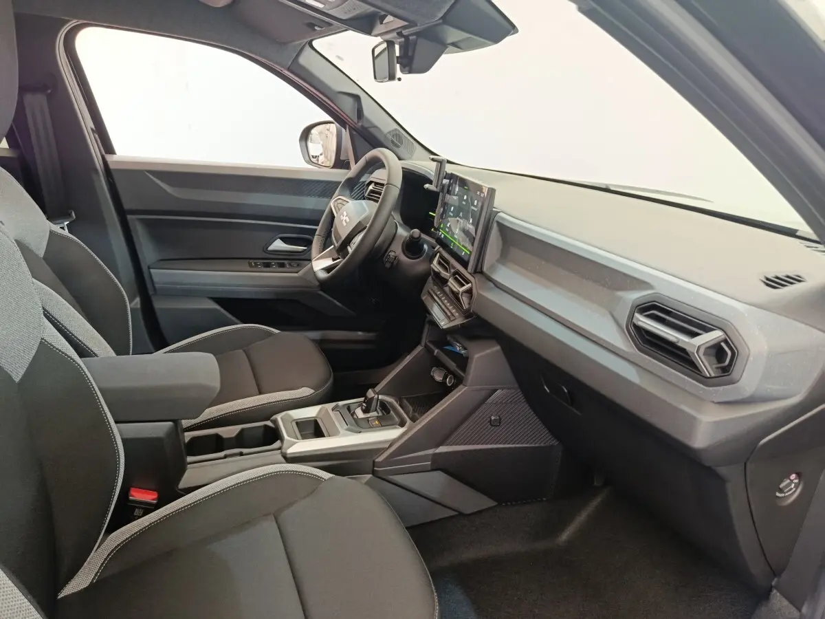 Vue intérieure côté conducteur du Dacia Duster noir 2026, mettant en valeur le tableau de bord moderne avec écran tactile central.