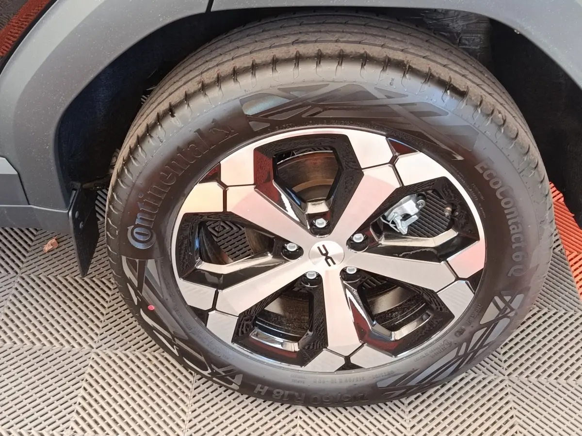 Gros plan sur la jante noire et argentée du Dacia Duster Journey Hybrid 155, avec pneu Continental visible.