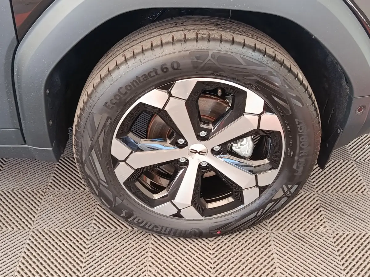 Gros plan sur la roue avant droite du Dacia Duster noir 2026, mettant en valeur la jante alliage bicolore et le pneu Continental.