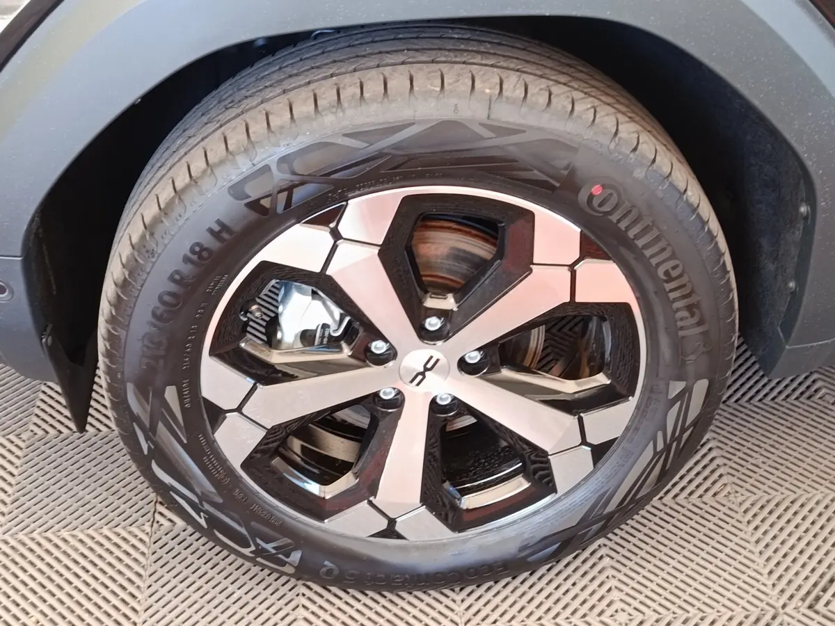 Gros plan sur la roue avant gauche du Dacia Duster Journey Hybrid 155 noir, avec jante alu bicolore et pneu Continental.