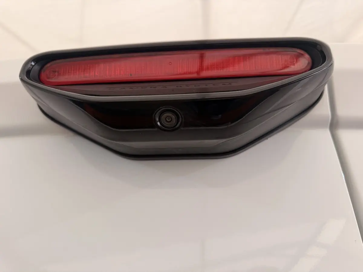 Détail du feu stop et caméra de recul sur la porte arrière blanche d’un Citroën Berlingo 2019.