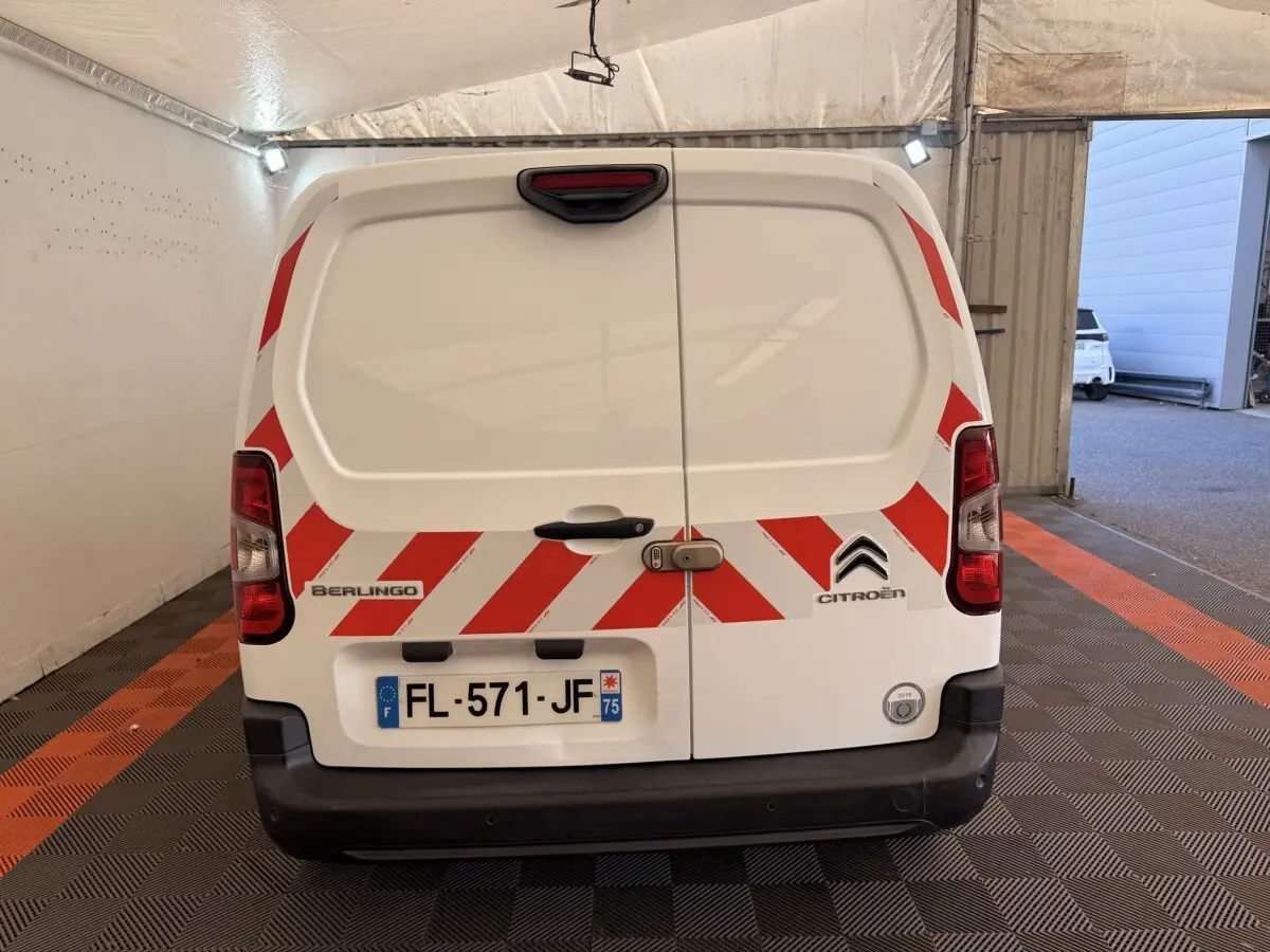 Vue arrière d’un utilitaire Citroën Berlingo blanc de 2019 avec bandes rouges réfléchissantes et plaque d’immatriculation française.
