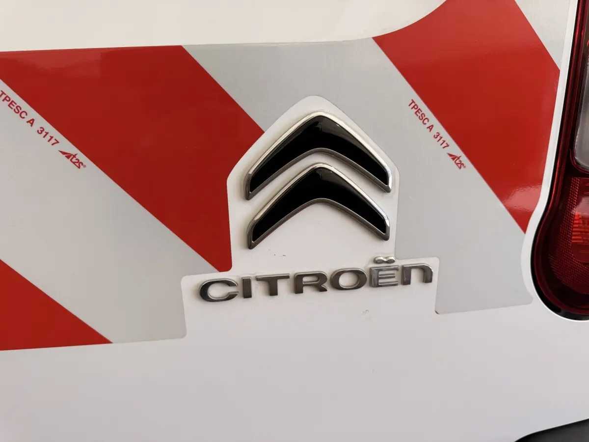 Gros plan sur l'arrière blanc d'un Citroën Berlingo 2019 avec marquage rouge réfléchissant et feu arrière droit visible.