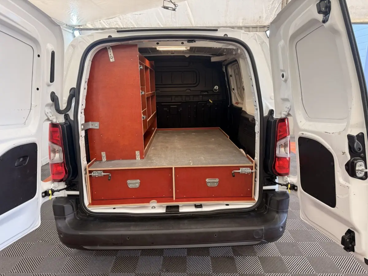 Vue arrière du Citroën Berlingo blanc 2019 avec portes ouvertes, montrant un aménagement bois dans l’espace de chargement.