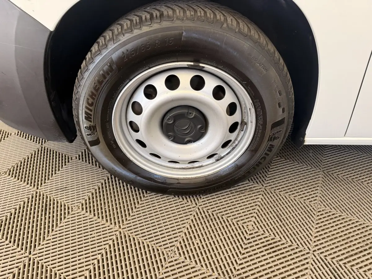 Gros plan sur la roue avant droite d’un Citroën Berlingo blanc 2019 avec jante acier et pneu Michelin.